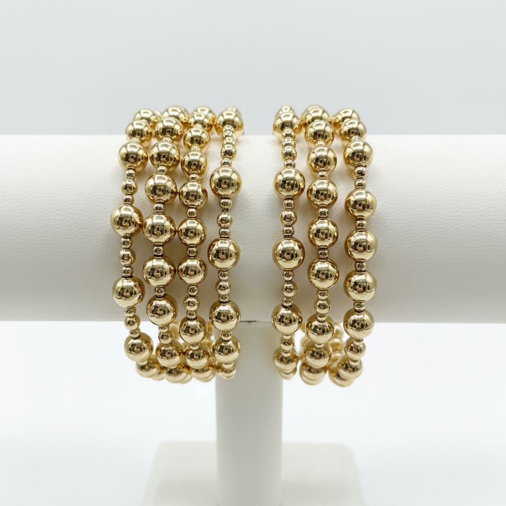 4 Gold Beaded Bracelets on White Display Stand