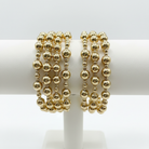 4 Gold Beaded Bracelets on White Display Stand